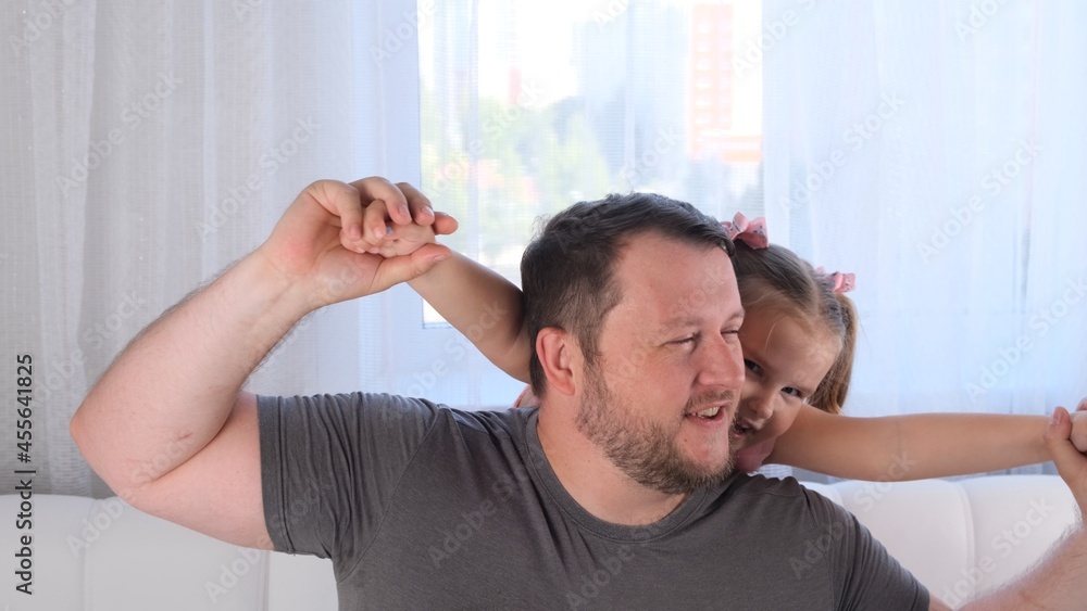 Portrait of smiling dad and daughter, 3 years old, playing at home. Fathers day. Handsome young man at home with his little cute girl are having fun together. Fatherhood concept, happy childhood Portrait of smiling dad and daughter, 3 years old, playing at home. Fathers day. Handsome young man at home with his little cute girl are having fun together. Fatherhood concept, happy childhood