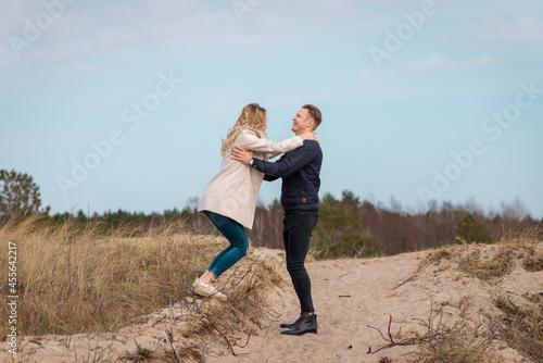Beautiful young couple enjoying spring beach vacation, playful on sunny blue sky outdoors.having fun and being active. © ARVD73