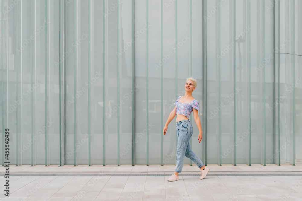 Young caucasian woman outdoor dancing celebrating success feeling free - advertising copyspace