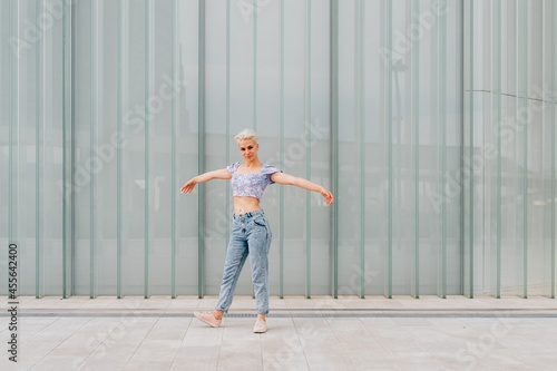 Young caucasian woman outdoor dancing celebrating success feeling free - advertising copyspace