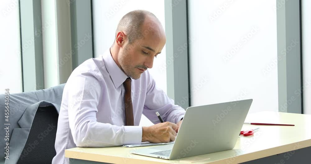 Business man holding laptop computer notebook and smiling at modern office with team. Business man holding laptop computer notebook and smiling at modern office with team.