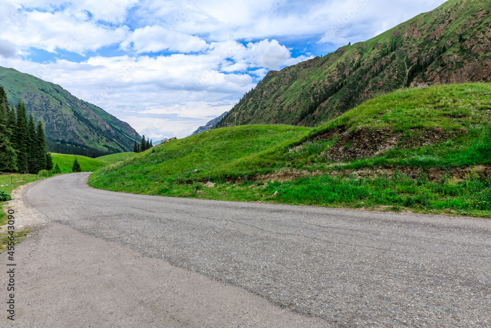 Asphalt road and green mountain natural landscape in Xinjiang,China.