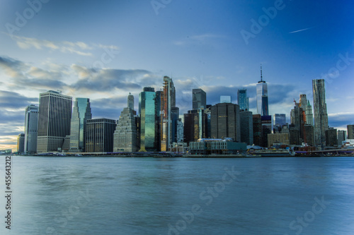Skyline di New York City. Fiume con palazzi illuminati come sfondo © Matteo
