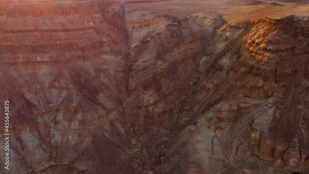 Aerial Forward Shot Of Tourists Exploring Top Of Brown Mountain, Drone Flying Forward Over Desert Landscape - Shaharut, Israel Aerial Forward Shot Of Tourists Exploring Top Of Brown Mountain, Drone Flying Forward Over Desert Landscape - Shaharut, Israel