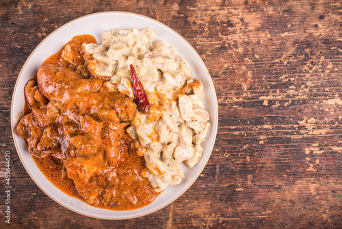 Hungarian chicken stew - chicken parikash with dumplings, gnocchi on plate, top view, copy space photo