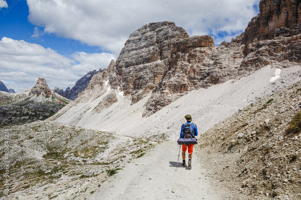 Man Traveler with backpack on the trail in Dolomites, Italy. Travel, Lifestyle, Sport concept