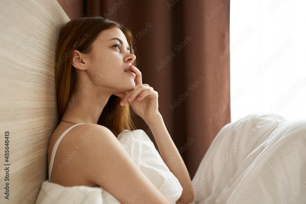 woman lies in bed morning with a phone in her hands communication woman lies in bed morning with a phone in her hands communication