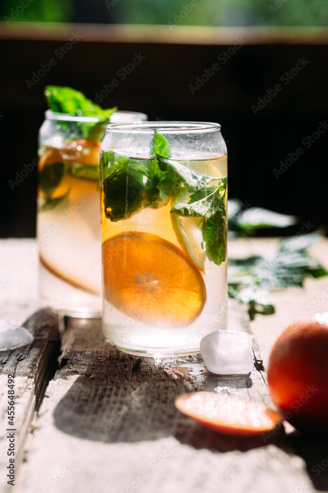 Cold cocktail with tangerine and mint on a wooden table Cold cocktail with tangerine and mint on a wooden table