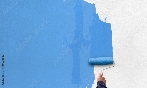 Fototapeta Naklejka Na Ścianę i Meble -  hand holds paint roller and painting a wall
