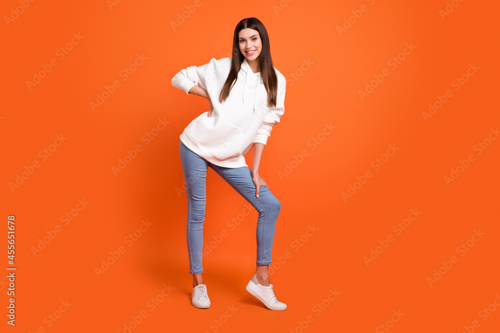 Full length body size view of attractive cheerful thin girl posing good mood isolated over bright orange color background Full length body size view of attractive cheerful thin girl posing good mood isolated over bright orange color background