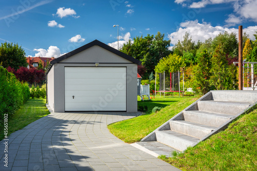 A detached garage in a green garden at summer