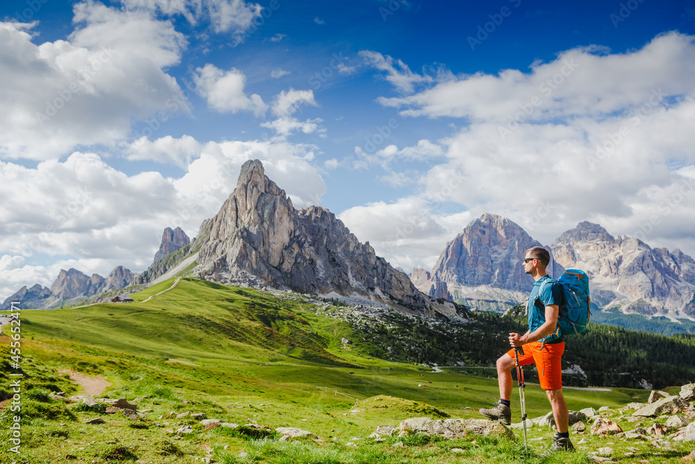 Young man with backpack on a mountain trail, Dolomites Mountains, Italy