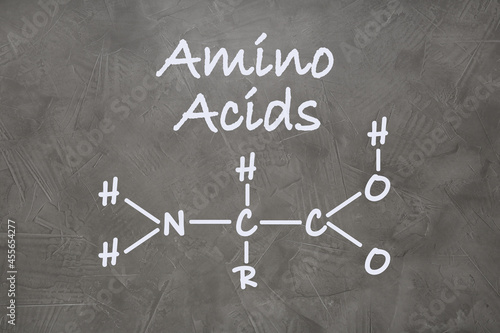 Text Amino Acids and chemical formula on grey stone surface