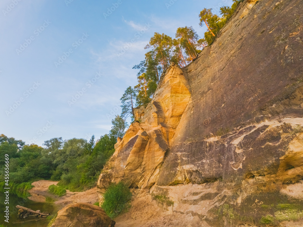 Peaceful landscape with Gauja river and red sandstone Erglu kliffs steep rocks in Gauja National Park in Valmiera area