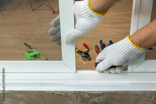 Photography Worker fixing the insect screen sliding door