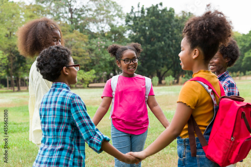 Group of African American children joining their hands in the park. Diverse black children joining their hands. Successful and teamwork concept © amorn