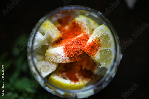 Hill lemon Indian pickle with red chilli powder, salt and other spices on top in a glass jar.