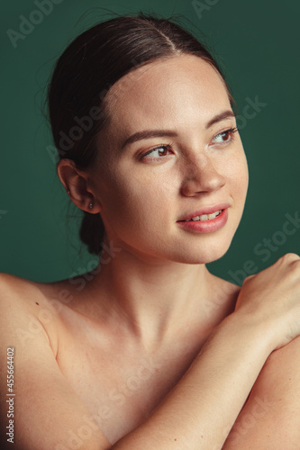 Close-up portrait of young beautifulgirl looking away isolated over green background photo