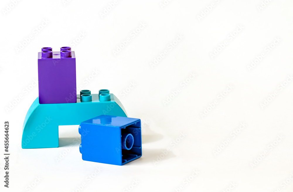 Details large blue purple children's plastic construction kit isolated on white with copy space. Toys for children. Colorful plastic toy blocks, solid blue constructor set. Details large blue purple children's plastic construction kit isolated on white with copy space. Toys for children. Colorful plastic toy blocks, solid blue constructor set.