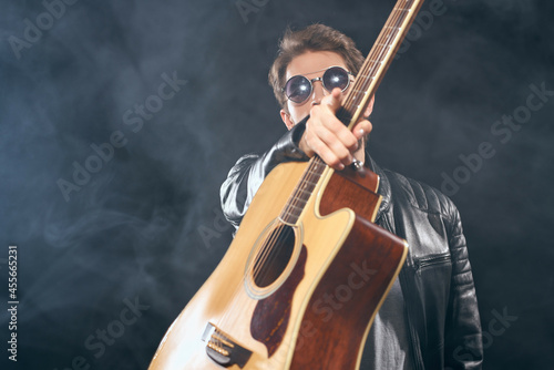 man in black leather jacket holding guitar music celebrity lifestyle