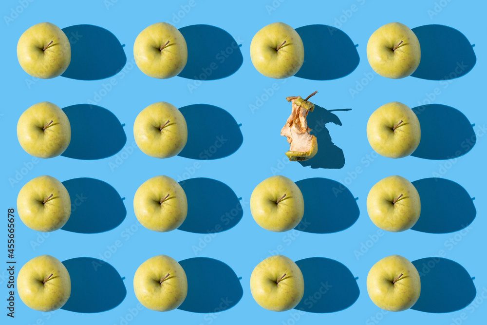 apple pattern with one eaten on a blue background apple pattern with one eaten on a blue background