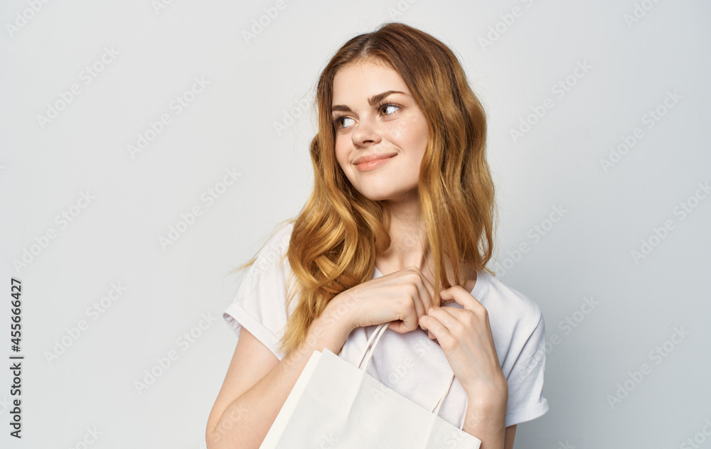 pretty woman in white t-shirt shopping bag in hands pretty woman in white t-shirt shopping bag in hands
