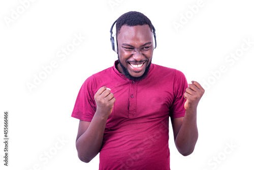 young happy man listening to music in headphones and making a winning gesture.