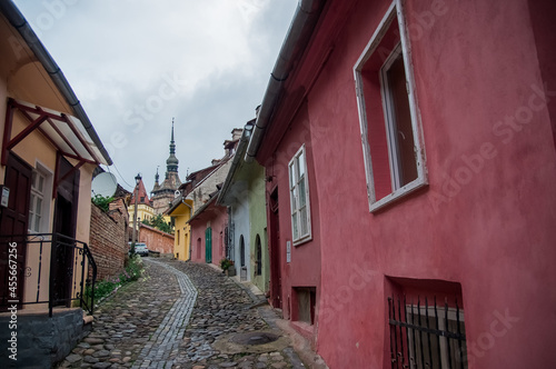 Wąska kamienna uliczka z kolorowymi budynkami © Monika