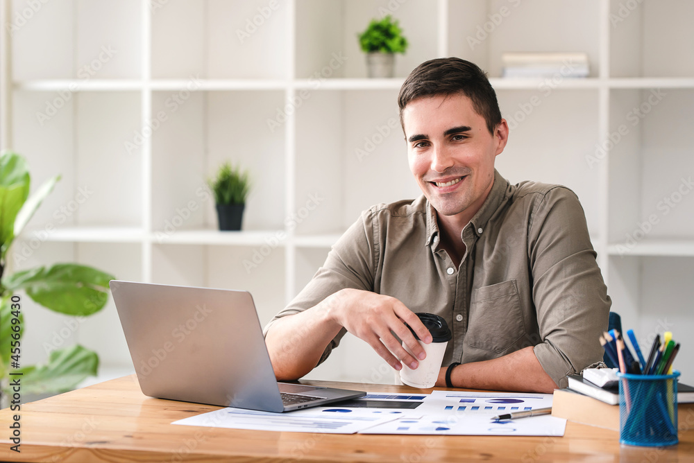 confident young businessman Work from home with laptop and documents on the desk. confident young businessman Work from home with laptop and documents on the desk.