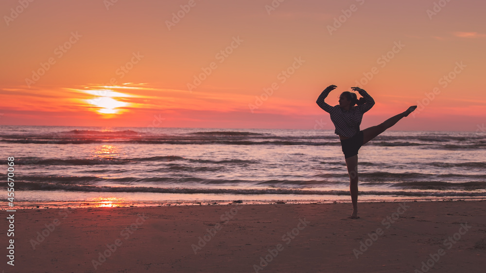 Jeune fille faisant du sport sur la plage, au coucher du soleil.