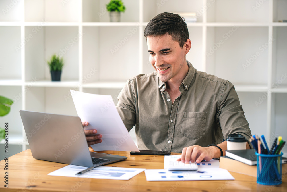 confident young businessman Work from home with laptop and documents on the desk. confident young businessman Work from home with laptop and documents on the desk.