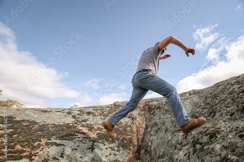 Man running and jumping on rocks in nature