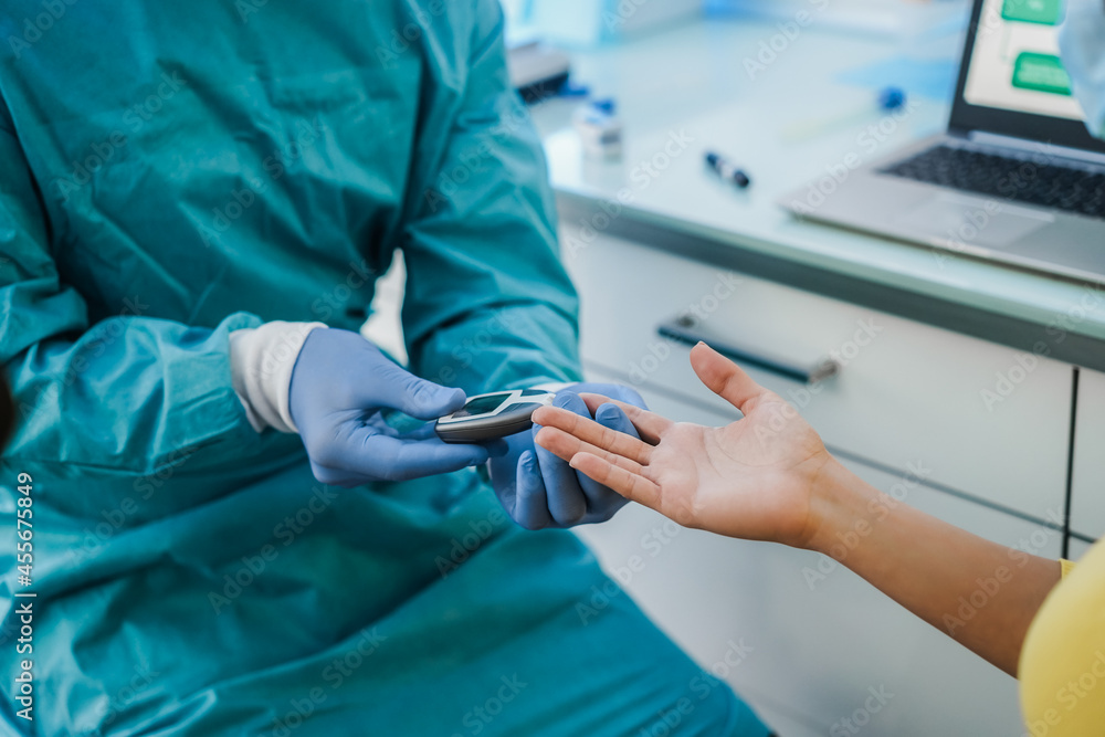 Medical doctor checking blood sugar level to young patient for diabetes disease control - Focus on woman hand Medical doctor checking blood sugar level to young patient for diabetes disease control - Focus on woman hand