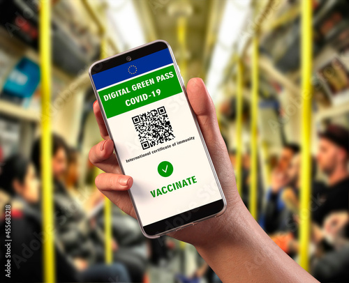 EU Digital Green Pass with QR code on a mobile screen, background interior of a metro carriage Covid-19 immunity. Travel without restrictions