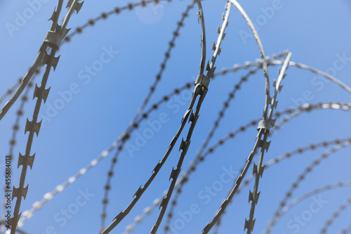 Rusted barbwire and chain link fence. Iron wire on blue sky background on a jail