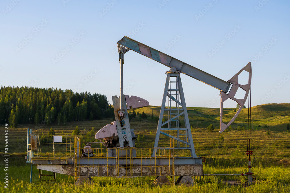 Working oil pump from oil field. Industrial equipment. Industrial equipment. Bashkortostan, Russia - 12 June, 2021. Working oil pump from oil field. Industrial equipment. Industrial equipment. Bashkortostan, Russia - 12 June, 2021.