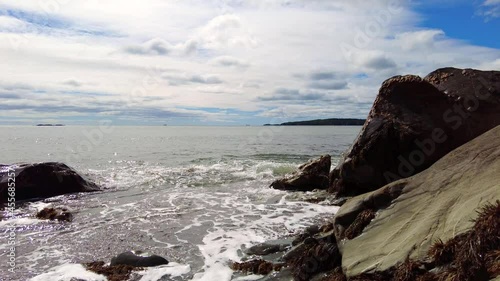 Surging Tide in Rocky Inlet with Cloudy Sky Background