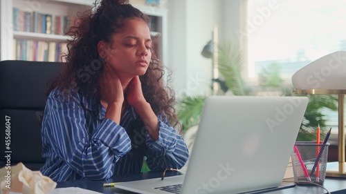 Exhausted young Indian woman feeling very tired at work or while studying online. Woman working on a laptop needs rest and healthy sleep. Concept of fatigue, exhaustion and stress.