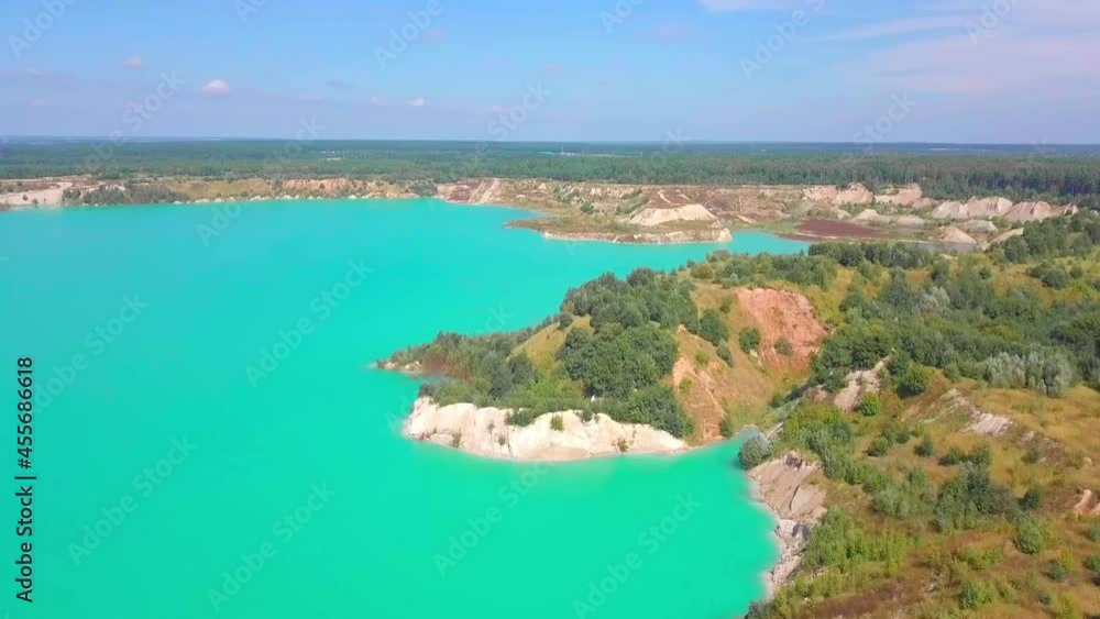 Artificial lake in a chalk quarry. Amazing industrial landscape. Drone view of opencast mine. Turquoise background of the water in open pit. Technogenic mountains formed during chalk mining. Artificial lake in a chalk quarry. Amazing industrial landscape. Drone view of opencast mine. Turquoise background of the water in open pit. Technogenic mountains formed during chalk mining.