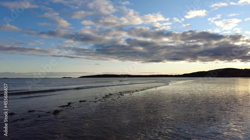 Pan of Golden Sunset on Tidal Flat with Gentle Rolling Waves