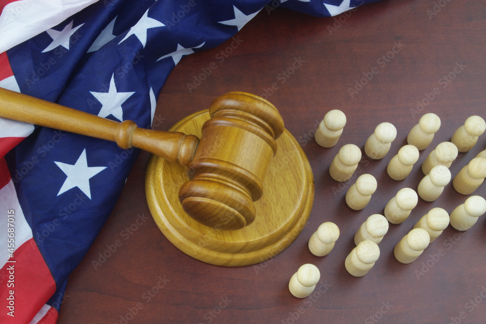 Judge gavel and USA flag with many wooden figures of people. Migration laws of United States 