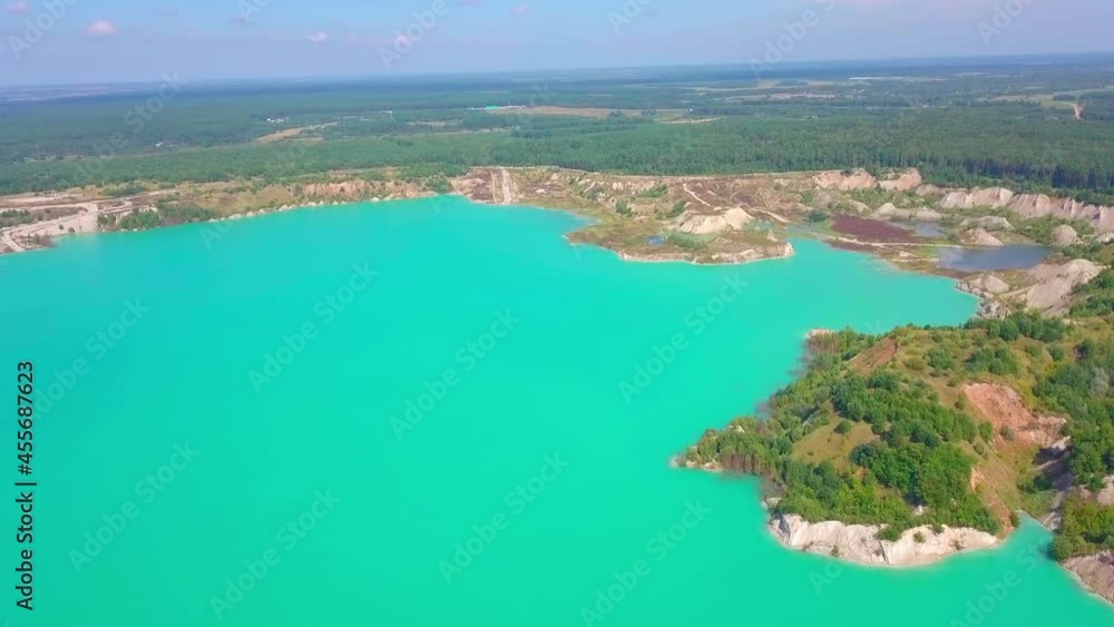 Artificial lake in a chalk quarry. Amazing industrial landscape. Drone view of opencast mine. Turquoise background of the water in open pit. Technogenic mountains formed during chalk mining. Artificial lake in a chalk quarry. Amazing industrial landscape. Drone view of opencast mine. Turquoise background of the water in open pit. Technogenic mountains formed during chalk mining.