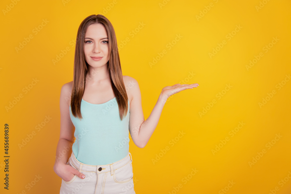 Portrait of cheerful nice beautiful lady hold invisible object hand pocket on yellow background Portrait of cheerful nice beautiful lady hold invisible object hand pocket on yellow background