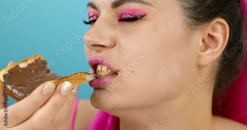 Close-up of a girl eating bread with chocolate. 