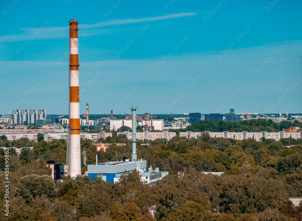 Obraz premium Summer cityscape. Industrial area of city. White and red factory pipe