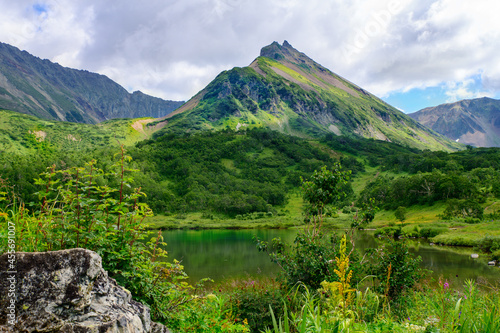 Landscape. Beautiful view of the mountain lake Tahkoloch and the crater of the ancient volcano Vachkazets, which has already become a mountain range. Kamchatka Peninsula