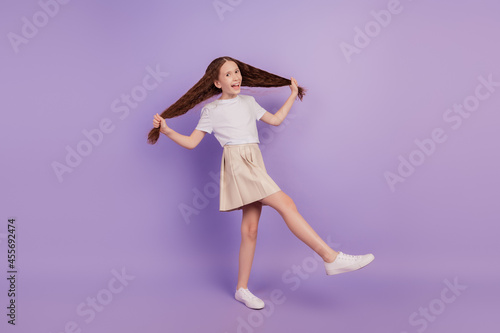 Portrait of funky positive careless girl hold tails dance party on purple background