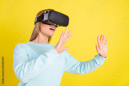 Photo of adorable pretty woman dressed blue pullover playing 3d game empty space isolated yellow color background