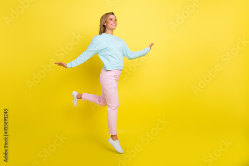 Full length body size view of pretty cheerful girl jumping going good mood copy space isolated over bright yellow color background