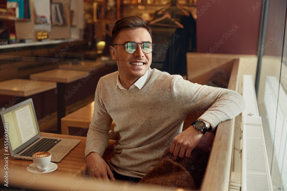 Businessman looking in window at table with laptop Businessman looking in window at table with laptop